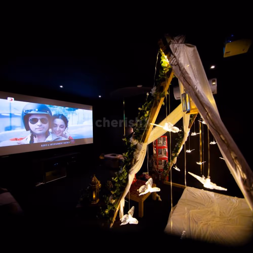 Elevate your movie night with a charming cabana setting, featuring rose-petal decor, love boxes, and intimate lighting.