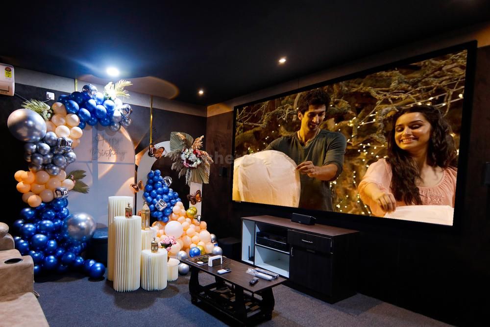 Indulge in an intimate movie night surrounded by captivating decorations—sunboard cut-outs and balloon arches.