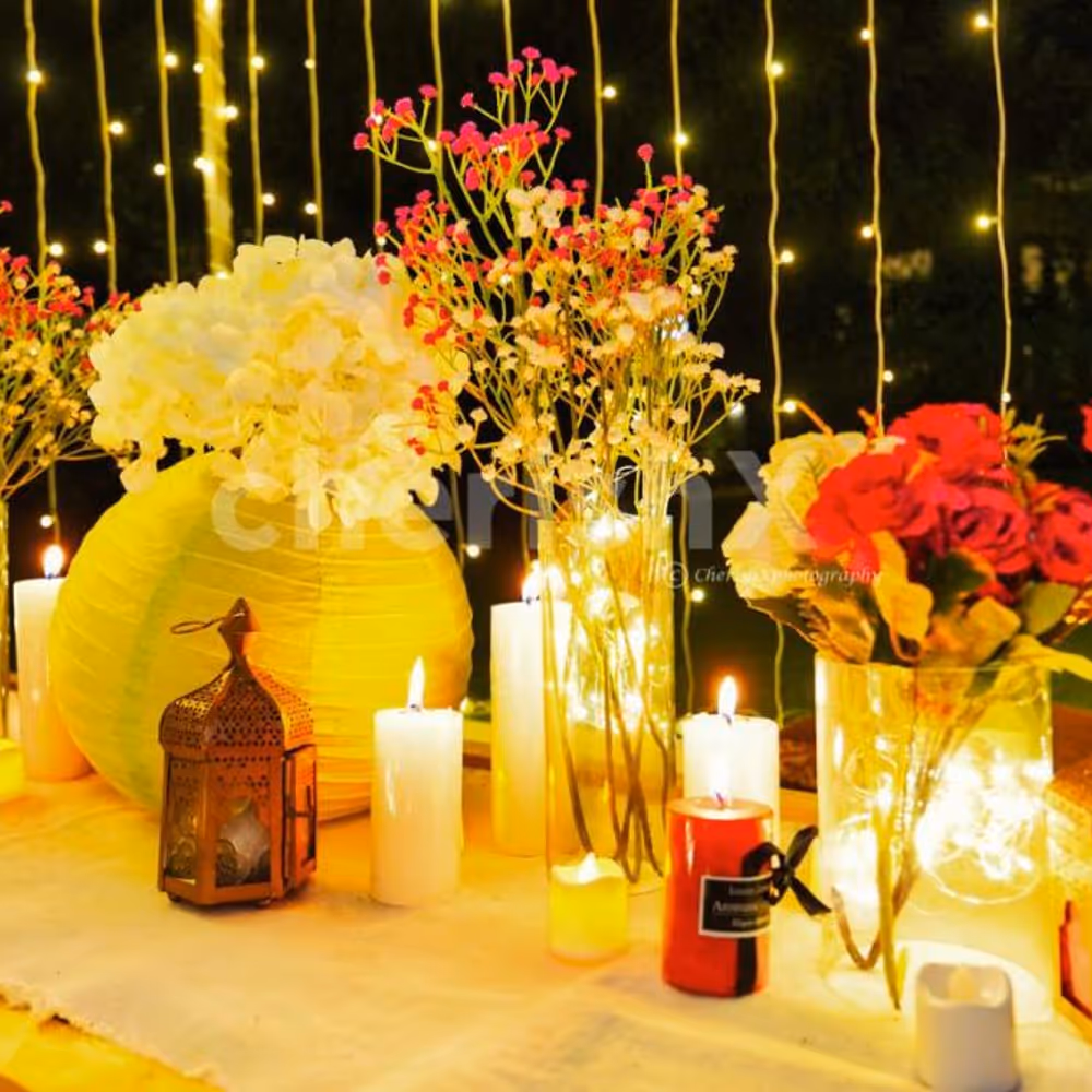 Low tables with white runners, pillar candles, and beautiful floral arrangements, set the stage for a charming and intimate dinner setting.