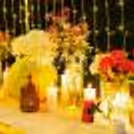 Low tables with white runners, pillar candles, and beautiful floral arrangements, set the stage for a charming and intimate dinner setting.