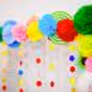 A beautiful arrangement of rosettes, pom-poms, and lanterns for a stunning Dusshera pooja decor.