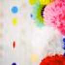 Elegantly set idols against a backdrop of rosettes, pom-poms, and lanterns for celebrations.