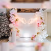 Immerse yourself in the enchantment of the Blissful Feather Fantasy baby shower decor featuring a dreamy setting with delicate pink balloon garlands, creating a joyful and celebratory atmosphere.