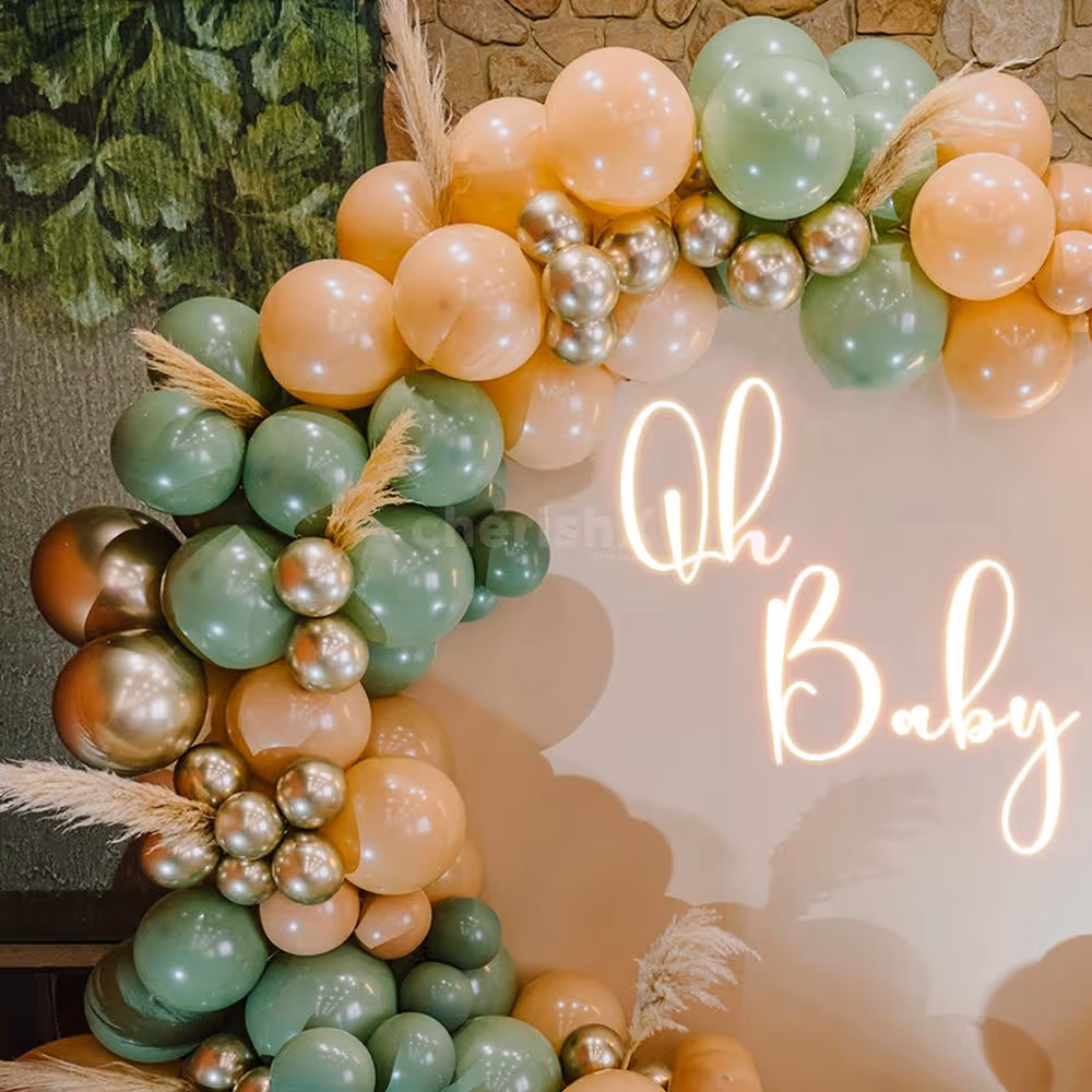 An arch of balloons in retro peach, vintage olive green, and golden chrome hues.