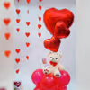 Bright red balloon stand, adding a festive and uplifting touch to the surprise.