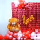 The decor is accompanied by a shiny foil curtain and a teddy bear.