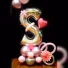 The base is accentuated with an arrangement of beautiful balloons in light pink chrome, pink pastel, and silver chrome
