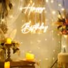 Elegantly decorated wooden candle stand with LED candles, surrounded by a jute mat, jute basket, and a vase boasting an artificial flower bunch and leaves."