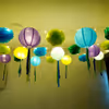 A collection of light green, dark green, and light blue pom poms, part of festive decorations.