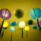 A variety of lanterns in purple, light blue, light green, and dark blue, illuminate the festive setting.