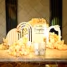 A charming pumpkin-themed baby shower consists of sunboard cutouts with stands, draped in 500 pastel balloons of peach, apricot, and chocolate brown.