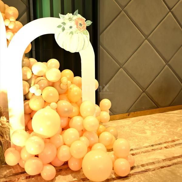 Theme round tables adorned with pumpkin-themed decor and a welcoming board featuring balloons and a sparkling disco light.
