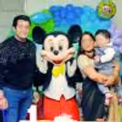 Mickey Mouse Family Photo in front of a blue balloon birthday backdrop