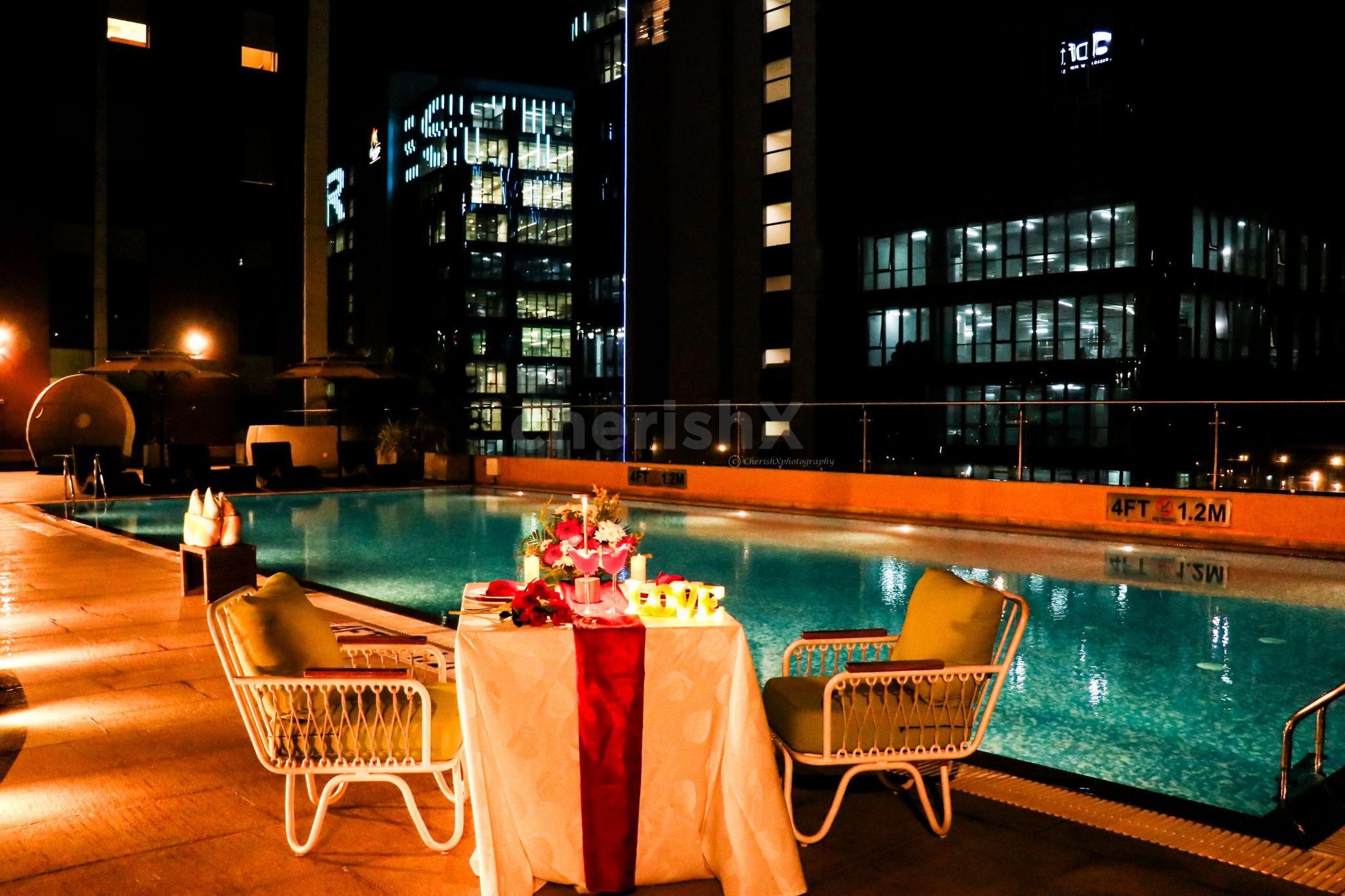 Enjoy a serene poolside setting with candlelight and flower decorations.