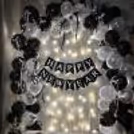 An alternative metallic white and black balloon arch creates a chess-like pattern on the wall.