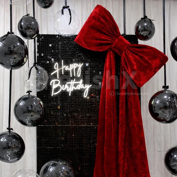 Black macron and bubble balloons with ribbons and bows resemble hanging stars.