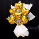 Golden foil balloons in heart shape waves in the air highlighting Valentine's Day sparkle