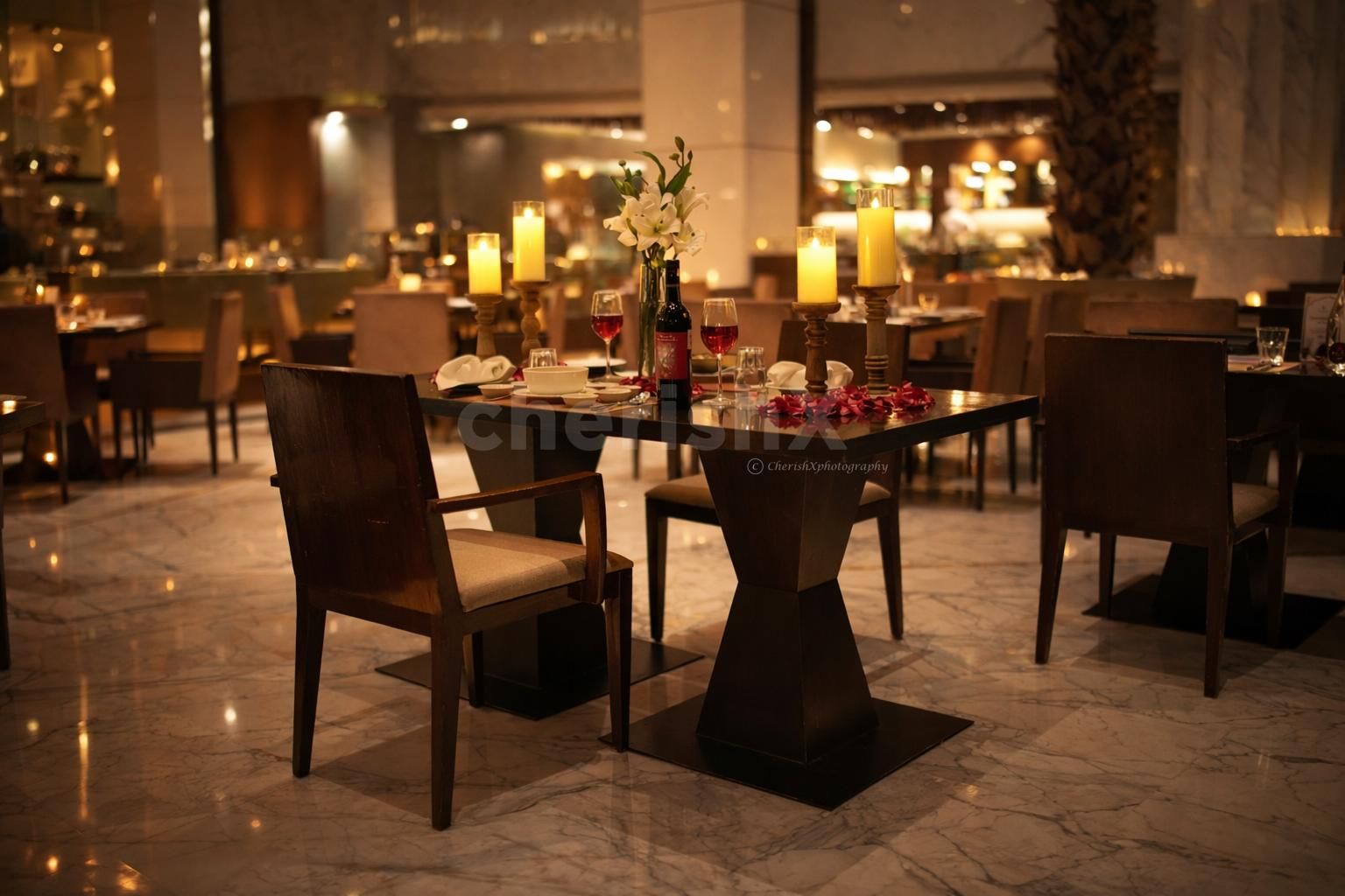 Elegant table décor with candles and rose petals for a luxurious indoor dining experience