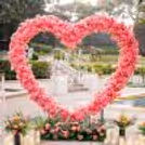 Heart stand wrapped with artificial peach flower becomes the backdrop for proposal