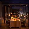 Romantic outdoor dinner setup with LED candles and rose petals