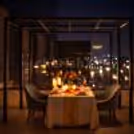 Romantic outdoor dinner setup with LED candles and rose petals