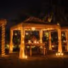 Elegant cabana setup with soft lighting and gourmet dishes for two