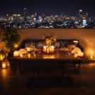 Romantic rooftop table setup with candles and flowers