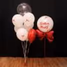 Five white helium balloons bring balance and elegance to the setup