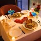 The Restaurant's Dinner Table Is Set With Candles And Rose Decorations For The Couple.