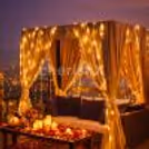 A private cabana adorned with stunning floral and balloon décor, illuminated with ambient lights