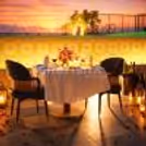 Elegantly decorated table with flowers, lights, and candles on the poolside lower deck.