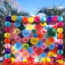 Fluffy colourful paper rosettes are joined together to form a photoready backdrop for Holi.