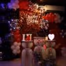 Couple movie setup with red and gold balloon décor for a love-filled vibe.