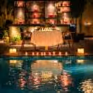An intimate poolside candlelight dining setup at Expo, Greater Noida, where warm lights, calm waters, and a beautifully decorated table create the perfect romantic evening.