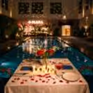 Experience romance by the pool at Expo, Greater Noida with a private candlelight dinner setup surrounded by elegant décor and shimmering reflections.