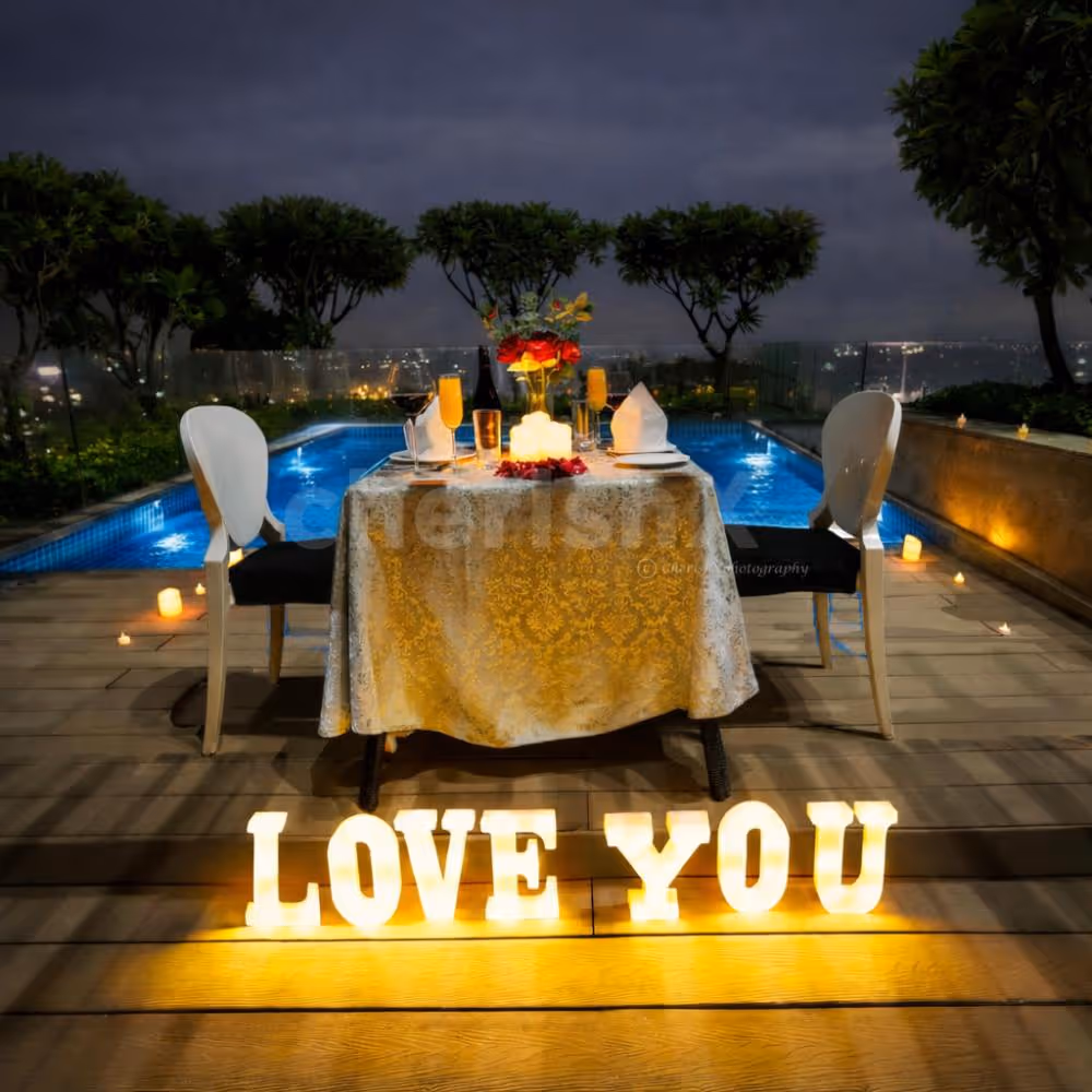 A magical rooftop poolside candlelight dining experience at Radisson Paschim Vihar, Delhi with city lights and romantic ambiance.