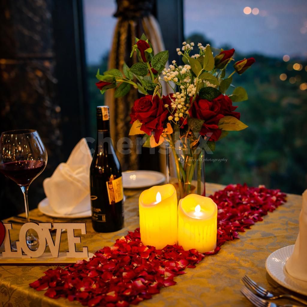 A dreamy evening setup with candles, roses, and a private table for two.