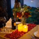 A dreamy evening setup with candles, roses, and a private table for two.
