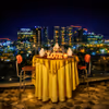 A romantic rooftop candlelight dinner overlooking the sparkling city skyline.