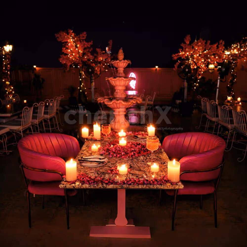 An intimate candlelight dining setup at Fiaba Cafe, where rose petals, warm candles, and handcrafted mocktails create the perfect romantic evening.