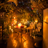 A hidden garden corner lit with candles, crafted for romance and slow evenings together.