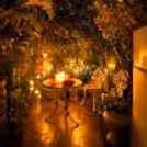 A hidden garden corner lit with candles, crafted for romance and slow evenings together.