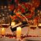 Indulge in a cozy candlelight dinner surrounded by roses, wine and warm ambient lighting.