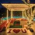 Relaxing Pergola Seating With A Fairy-Light Backdrop, Creating A Romantic Dining Setting.