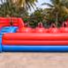 Kids enjoying giant inflatable obstacle bouncy setup with climbing and sliding activities at birthday party