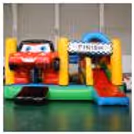 Kids Enjoying Sliding And Racing On A Car-Themed Inflatable Bouncy
