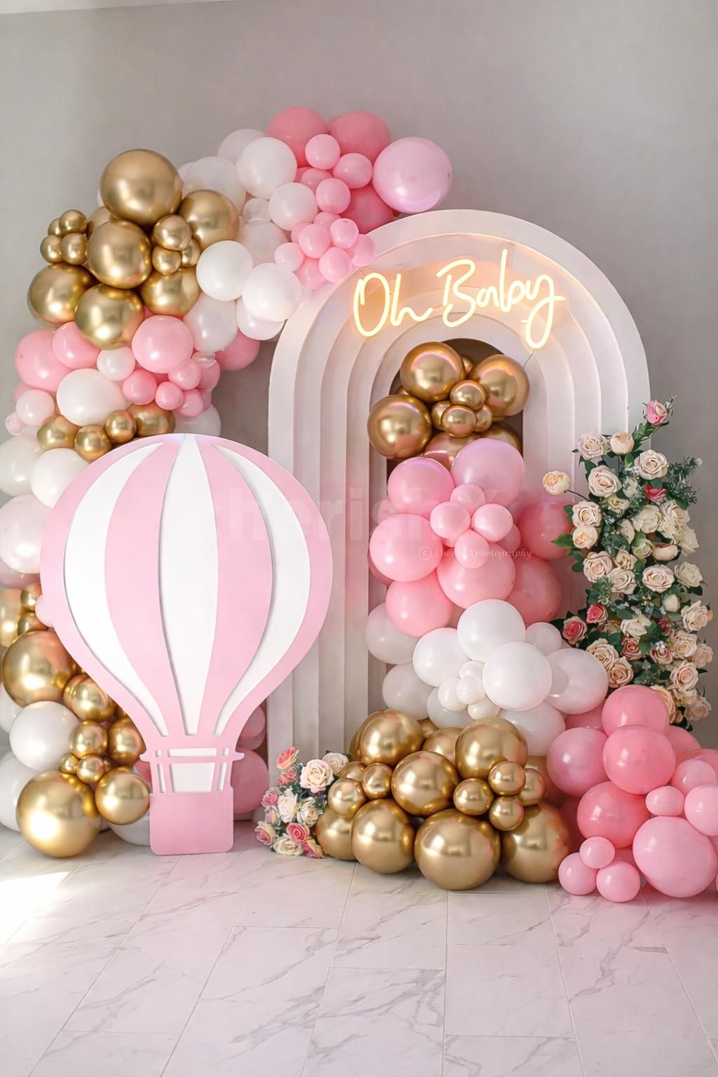 An organic balloon cluster in pastel and blush pink, white, and golden is eye-catching.