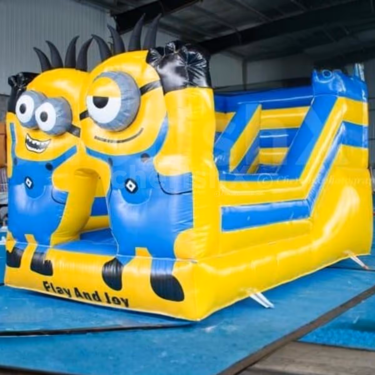Bright Yellow And Blue Minion-Themed Castle Setup For A Kids' Party With A Slide