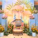 Chair With Peacock Props, Bunches Of Fresh Flowers, And Warm White Brick Lights.
