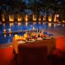 The Romantic Table Setup Is Well Decorated With Rose Petals And Candlelights That Steal The Show